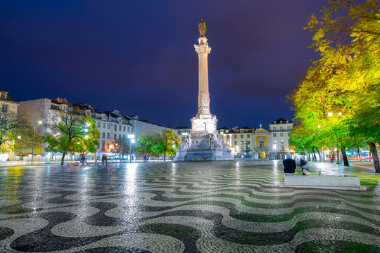 One of the most beautiful squares in Europe surrounded by jacaranda trees, stylish lanterns. Rossio Square(Pra&ccedil;a Dom Pedro IV, Pra&ccedil;a do Rossio) Lisbon, Portugal. Beautiful night cityscape longexposure