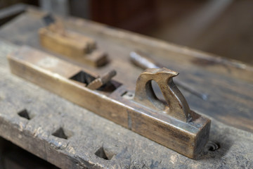 Old planer on a wooden carpentry table. DIY accessories in an old workshop.