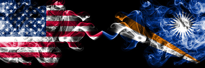 United States of America vs Marshall Islands smoky mystic flags placed side by side. Thick colored silky smoke flags of America and Marshall Islands
