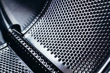Detail of the drum of a washing machine, steel industrial texture with holes.