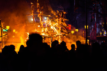 Group of people contemplating how a cardboard monument burns in Valencian Fallas.