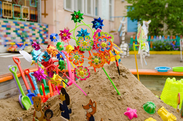 lot of children's multi-colored shovels with bucket in sandbox on the playground