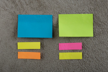 Many colorful sticky note on grey cement background. Copy space