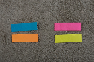Many colorful sticky note on grey cement background. Copy space