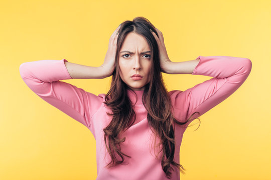 Disappointment stressed woman with headache isolated on yellow background