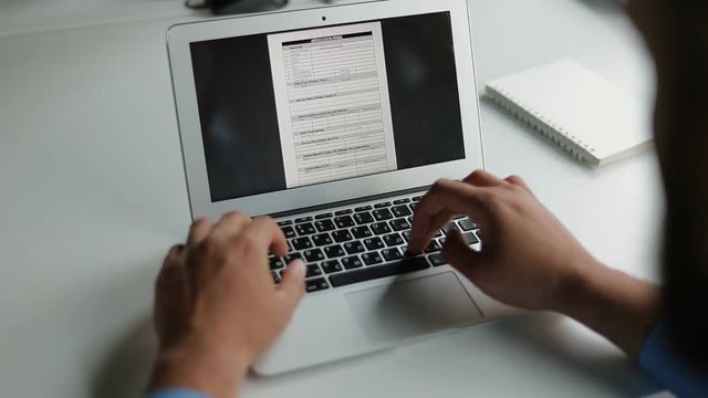 Cropped shot of young man filling form on laptop. Slow motion shot of male hands typing  on modern device. Technology concept
