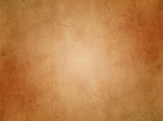 An elegant, brown, tan, grunge parchment texture background with glowing center and copy space for...