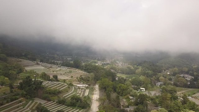Dropping down into a small village full of lower level fog in Mae Hong Son Northern Thailand
