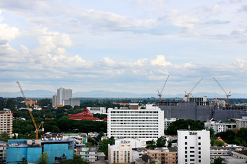 tall buildings under construction and cranes under a blue sky