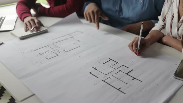 Cropped shot of architects studying blueprints. Professional employees working in office together. Concept of architecture plan