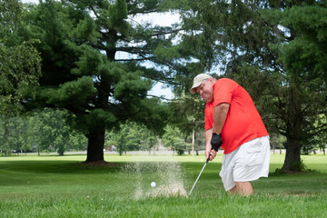 Golfer hitting out of a sand trap