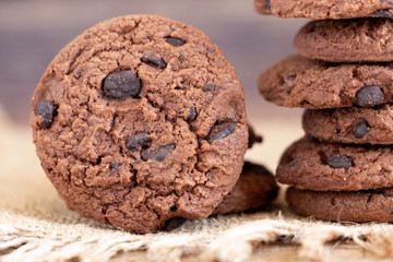 Chocolate chip cookies on sackcloth on wood table. Copy space for your text or image.