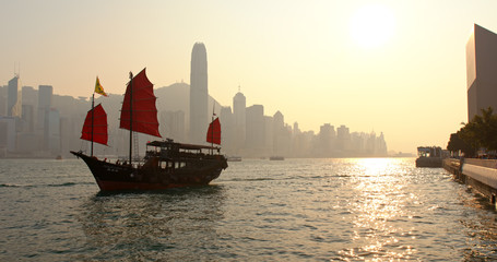Hong Kong Victoria harbor and red sail junk boat in the evening