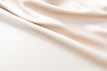 The texture of the satin fabric of beige color for the background 