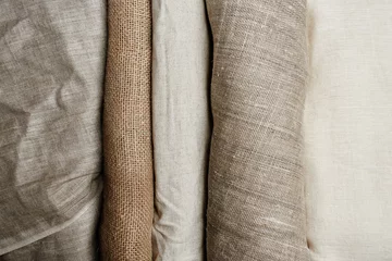 Fototapeten Natural fabrics from organic colors of flax and cotton in rolls, homespun textile handmade. Burlap and canvas for eco, rustic, boho, hygge decor © amixstudio