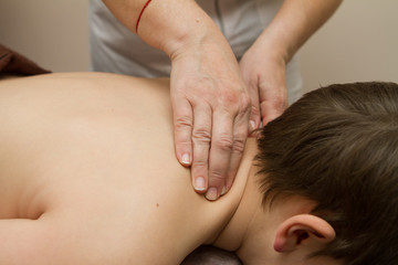 Fototapeta na wymiar the masseur gives the child a back massage