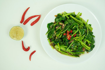 Chinese kale stir fried with oyster sauce, fish sauce, garlic and red chilli pepper in white plate on white background. 