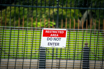security fence border wall with do not enter sign