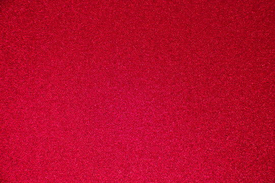 An abstract red background made of twinkling glitter that is great for a background for Christmas and other celebrations.