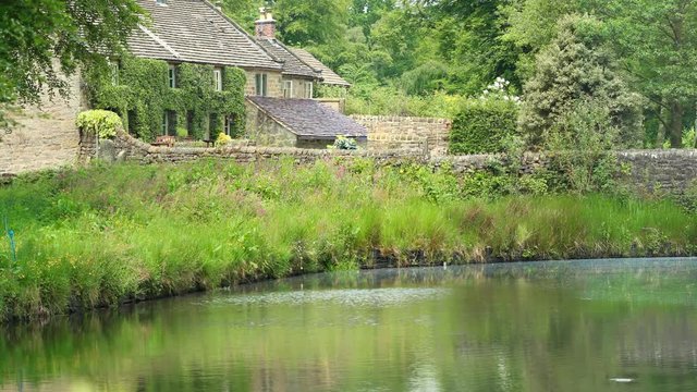 Picturesque stone bridge and the Pond Cottages over the Bentley Brook, Peak District, England. Panorama.