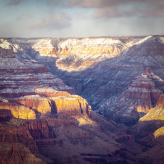 Evening image looking into the Grand Canyon with dramatic evening sunlight casting light and shadows in the canyon.