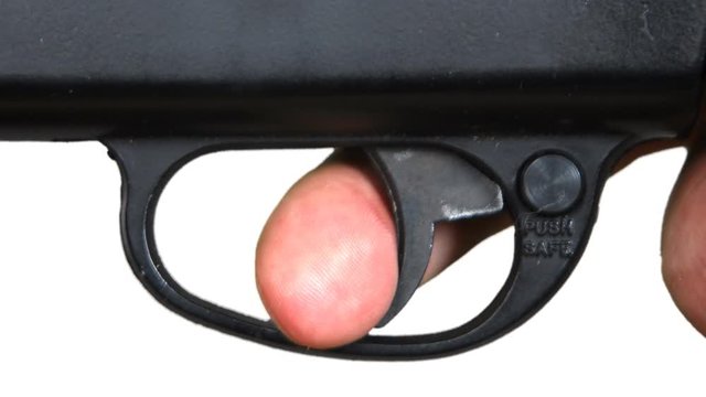 Pulling a trigger of a gun against a white background