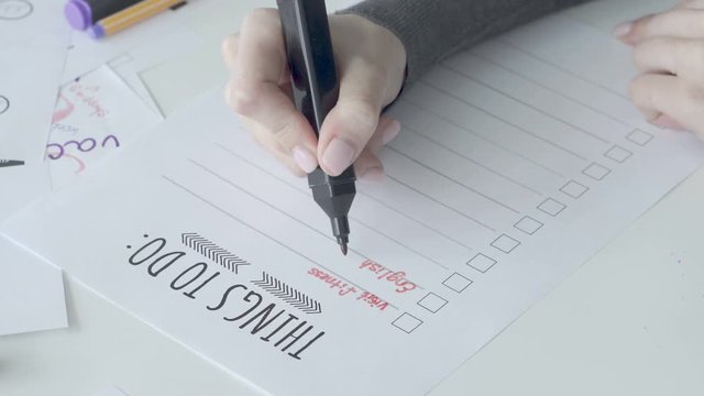 Woman in a dark sweater filling a to do list