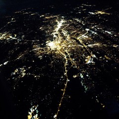 Flying at night over cities below