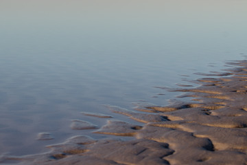 rippled sand meets serene water background, beautiful peaceful scene