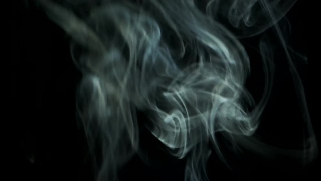 Smoke slowly rising graceful twists upward. Cigar smoke blowing from bottom to top. Natural color tobacco smoke. Great for editing, video without color correction and grading, 4K - 60fps