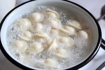 meat dumplings are boiled in a pot of boiling water
