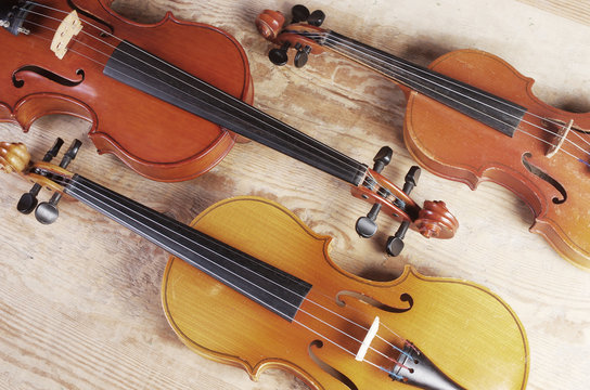 Three Violins On A Wooden Table