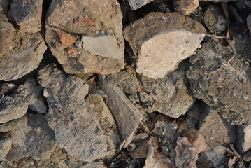 Construction trash, various construction stones, broken bricks, broken foundation and building materials. Bright and excellent background in sunlight.