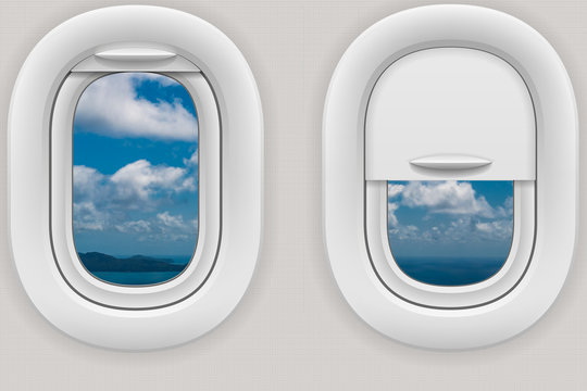 Fenster im Flugzeug mit Blick auf eine Insel unter Wolken