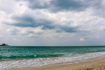 Fototapeta na wymiar Horizon of Seascape, water waves at Jumeirah Beach under cloudy sky in Dubai, United Arab Emirates