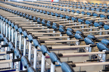Close up row of empty luggage trolleys in airport.