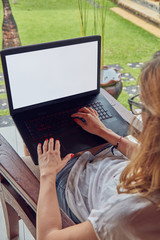 Girl using laptop on a home porch / terrace.