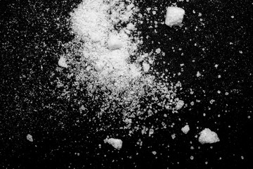 white crystalline powder on a black background. sugar dust 