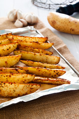 Baked potato wedges on tray - homemade organic vegetable, vegan potato wedges snack