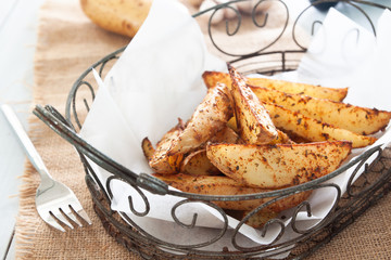 Baked potato wedges on basket - homemade organic vegetable, vegan potato wedges snack food meal