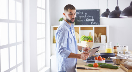 Smiling and confident chef standing in large kitchen