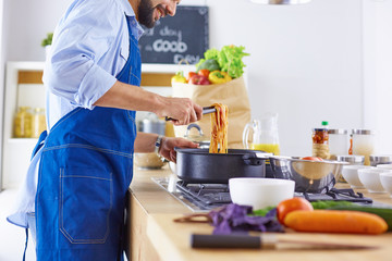 Smiling and confident chef standing in large kitchen