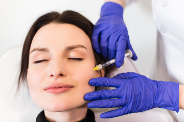A woman on the procedure of injections in a cosmetology clinic. lose top view