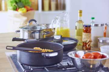 Pasta rolled on fork over pan on stove in the kitchen
