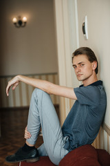 Fototapeta premium A man in a blue polo poses for menswear advertising. Shooting for men's clothing store