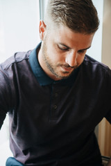 Fototapeta premium A man in a purple polo and posing for advertising men's clothing. Shooting for men's clothing store