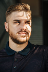 Obraz premium A man in a purple polo and posing for advertising men's clothing. Shooting for men's clothing store