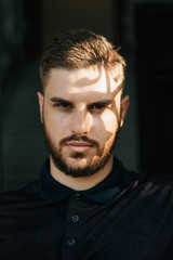 A man in a purple polo and posing for advertising men's clothing. Shooting for men's clothing store