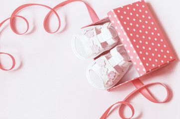 children's white sandals in a box with a ribbon close-up. festive background with girl sandals for newborn. the view from the top. copy space.