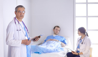 Doctor checking heart beat of patient in bed with stethoscope